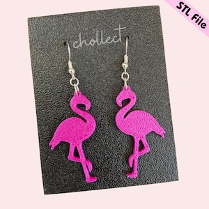 May include: A pair of pink flamingo earrings with silver hooks. The earrings are on a black card with the word "cholleect" printed on it.