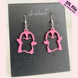 May include: A pair of pink penguin-shaped earrings with silver hooks. The earrings are displayed on a black surface with the word "chollect" and the text "STL File (for earrings only)" visible.