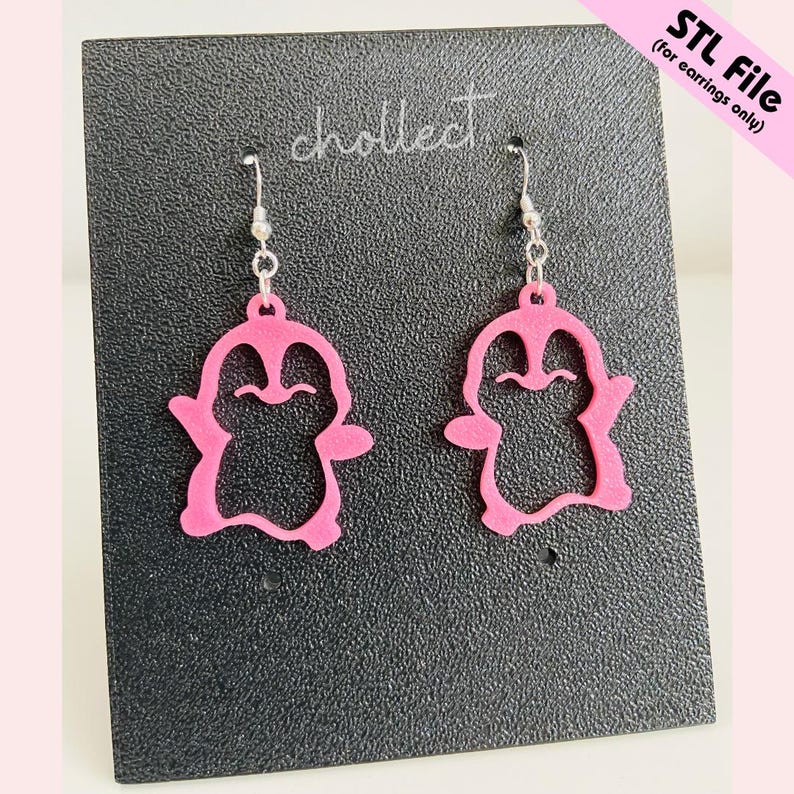 May include: A pair of pink penguin-shaped earrings with silver hooks. The earrings are displayed on a black surface with the word "chollect" and the text "STL File (for earrings only)" visible.