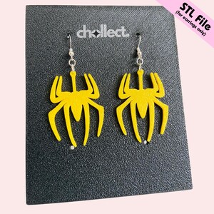 May include: A pair of yellow spider-shaped earrings with silver hooks. The earrings are displayed on a black textured surface with the text "STL File (for earrings only)". The brand name "chollect." is also visible.