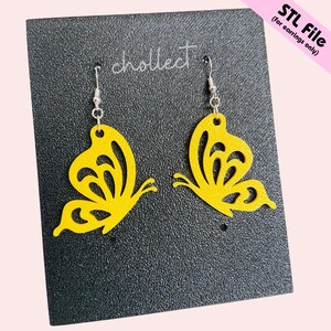 May include: A pair of yellow butterfly earrings with silver hooks. The earrings are displayed on a black textured card with the word "chollect" printed in white. The text "STL File (for earrings only)" is in the upper right corner.