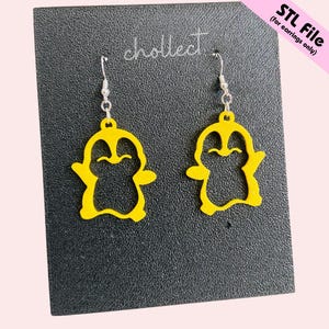 May include: A pair of yellow penguin earrings with silver hooks. The earrings are presented on a black surface. The text "chollect" and "STL File (for earrings only)" are visible.