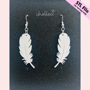 May include: A pair of white feather-shaped earrings with silver-colored hooks. The earrings are displayed against a black background with the word "chollect" in cursive. The text "STL File (for earrings only)" is in the upper right corner.