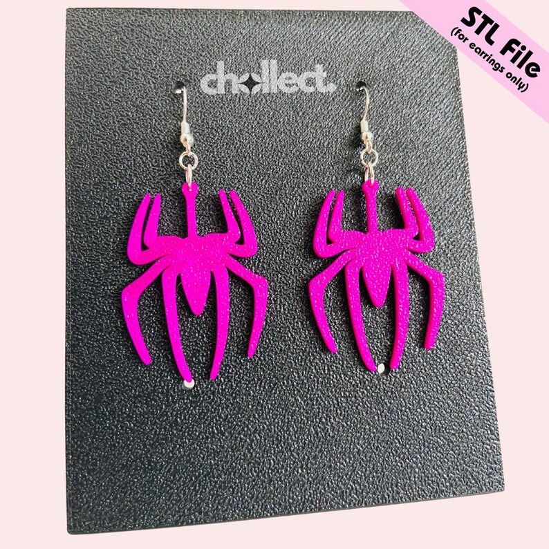 May include: A pair of hot pink spider-shaped earrings with silver-colored hooks. The earrings are displayed on a black surface with the text "STL File (for earrings only)" in the upper right corner. The brand name "chcollect" is also visible.