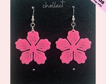 May include: Two pink flower earrings with silver hooks, displayed against a black background. The earrings are a floral design. The text "cholllect" is visible, along with "STL File (for earrings only)".