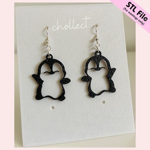 Puede incluir: Pendientes negros con forma de pingüino y ganchos plateados. Los pendientes están recortados, mostrando el contorno del pingüino. Se exhiben en una tarjeta blanca con la palabra "chollect" impresa. El texto "STL File (for earrings only)" está en la esquina superior derecha.