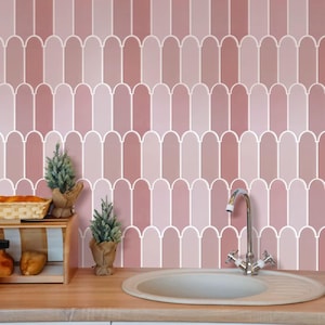 Op de afbeelding: Een roze en witte betegelde achterwand met een witte rand om elke tegel. De tegels zijn in een verspringend patroon gerangschikt. Een witte porseleinen gootsteen bevindt zich op de voorgrond.