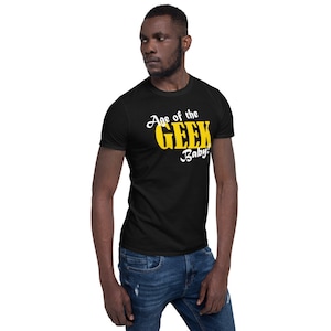 May include: A black t-shirt with a white graphic that says "Age of the Geek Baby!" in yellow letters.