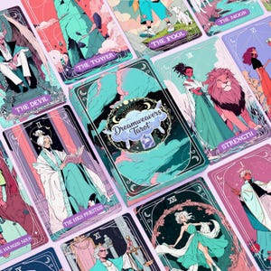 May include: A set of tarot cards with illustrations in teal, pink, and purple. The card backs display the text "Dreamweavers Tarot". Individual cards feature figures and titles including "The Fool", "The Tower", and "Strength".