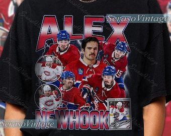 May include: Black t-shirt featuring a graphic of a hockey player with the name "ALEX NEWHOOK" in red and white. The design includes multiple images of the player in a red and blue hockey uniform. The shirt has a vintage style.