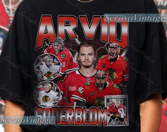 May include: Black t-shirt featuring a vintage design with the name "ARVID SODERBLOM" in red and white. The shirt includes images of a hockey player in a red and white uniform, with the text "Seraso Vintage".
