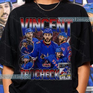 May include: Black t-shirt featuring a vintage design with the name "VINCENT TROCHECK" in red and blue. The shirt includes multiple images of a hockey player in a blue uniform, with the team logo "NYR".