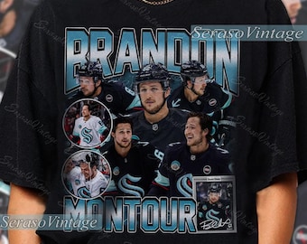 May include: Black t-shirt featuring a collage of hockey player Brandon Montour. The design includes the name "BRANDON MONTOUR" in a teal font, along with multiple images of the player in action. The shirt has a vintage aesthetic.