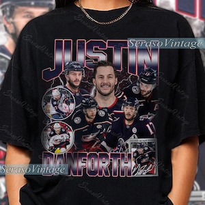 Puede incluir: Camiseta negra con un diseño del jugador de hockey Justin Danforth. El diseño incluye su nombre y fotos de él con su uniforme de hockey. La camiseta tiene un estilo vintage.