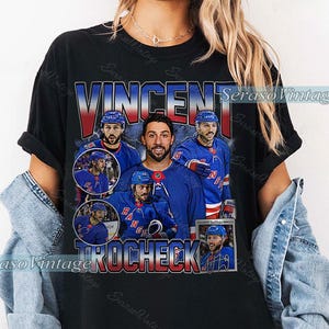 May include: Black t-shirt featuring a collage of images of Vincent Trocheck in a New York Rangers hockey uniform. The shirt has the name "VINCENT" in large letters and "TROCHECK" below. The design has a vintage aesthetic.