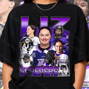 Könnte beinhalten: Schwarzes T-Shirt mit einem lila und weißen Design, das eine Hockeyspielerin zeigt, mit dem Namen "LIZ SCHEPERS" in lila Blockbuchstaben. Das Design umfasst Actionaufnahmen, einen Hockeyhelm und den Teamnamen "ODY CREEK LLERS".