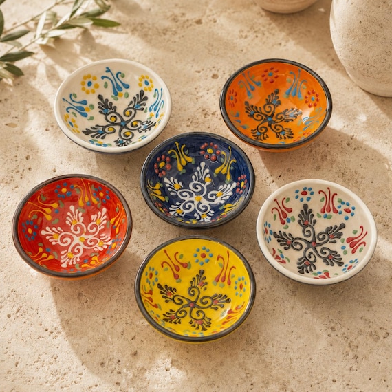 Tiny hand-painted ceramic bowls that pull triple duty as a snack dish, olive bowl, or ring holder — each one a little one-of-a-kind painting.