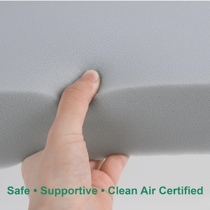 May include: A hand squeezes a section of grey foam. The foam has a soft, textured surface. Text at the bottom reads: Safe &bull; Supportive &bull; Clean Air Certified.