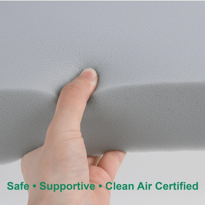 May include: A hand squeezes a section of grey foam. The foam has a soft, textured surface. Text at the bottom reads: Safe &bull; Supportive &bull; Clean Air Certified.