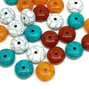 May include: A selection of round beads in shades of turquoise, white with grey veining, orange, and reddish-brown. Each bead features a central hole for threading. Ideal for crafting jewellery.