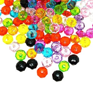 May include: A collection of faceted, colorful beads in various shades including orange, yellow, green, blue, pink, purple, and black. The beads are round with a central hole, suitable for jewelry making or crafting projects.