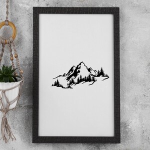 May include: Black and white silhouette of a mountain range with trees in front of it. The image is framed in a black frame.
