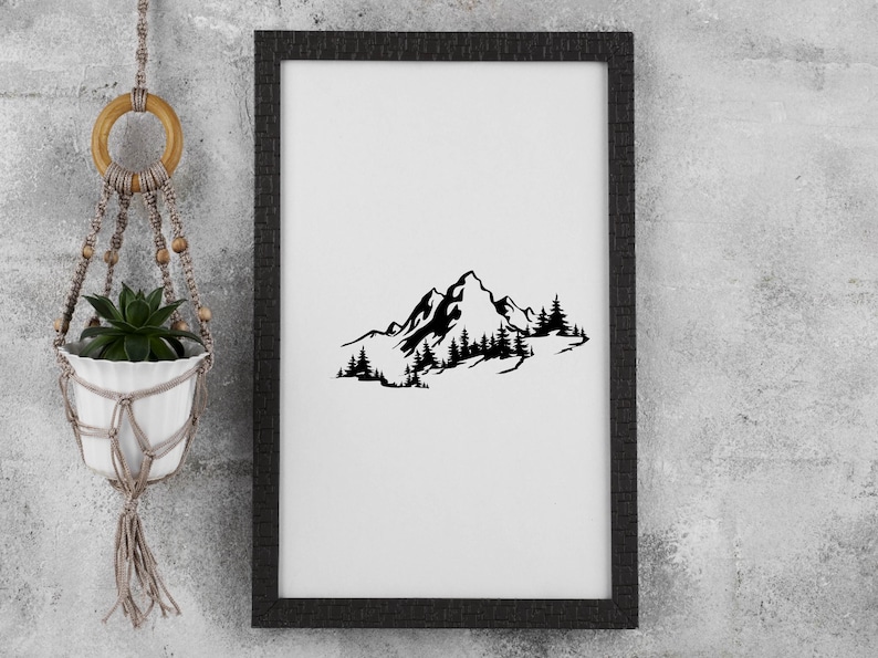 May include: Black and white silhouette of a mountain range with trees in front of it. The image is framed in a black frame.
