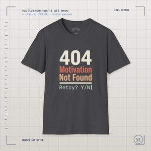 Könnte beinhalten: Ein anthrazitfarbenes Kurzarm-T-Shirt mit dem Text 404 Motivation Not Found und Retry? Y/N in cremefarbener und orangefarbener Schrift. Das T-Shirt besteht aus 100% Baumwolle und hat einen Rundhalsausschnitt mit Standardpassform und weichem Stoff.