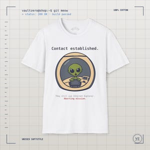 May include: A white short-sleeve t-shirt featuring a graphic of a green alien inside a circular spacecraft window. Text above reads Contact established. Text below reads They still use Internet Explorer. Aborting mission. The shirt is 100% cotton.