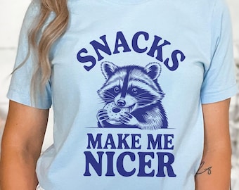 Divertente maglietta con grafica a forma di procione, regalo per amanti degli animali, maglietta umoristica con snack stravaganti, abbigliamento casual accogliente, regalo per appassionati di fauna selvatica eccentrica.