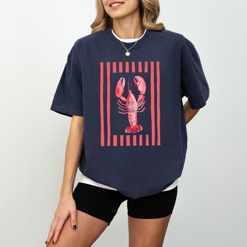 Navy t-shirt with red lobster graphic and vertical stripes.
