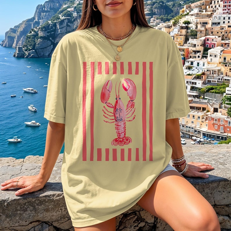 Yellow t-shirt with a pink lobster and red stripes design.
