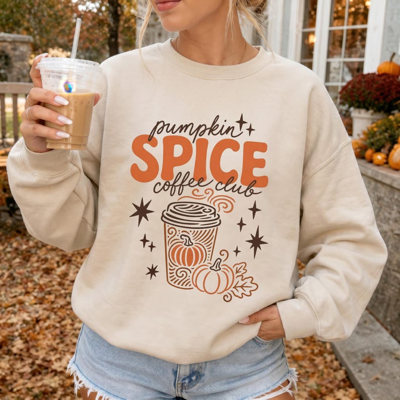 Cream sweatshirt with orange "Pumpkin Spice Coffee Club" graphic and coffee cup.