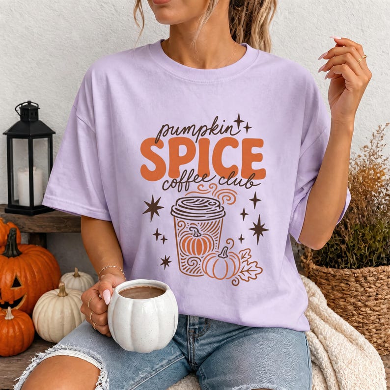 Lilac t-shirt with "pumpkin spice coffee club" graphic and pumpkin illustrations.