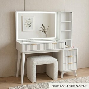 May include: A white vanity set featuring a rectangular mirror with integrated LED lighting, a fluted drawer front with gold handles, and an open shelving unit. The set includes a matching white textured stool and a three-drawer cabinet base.
