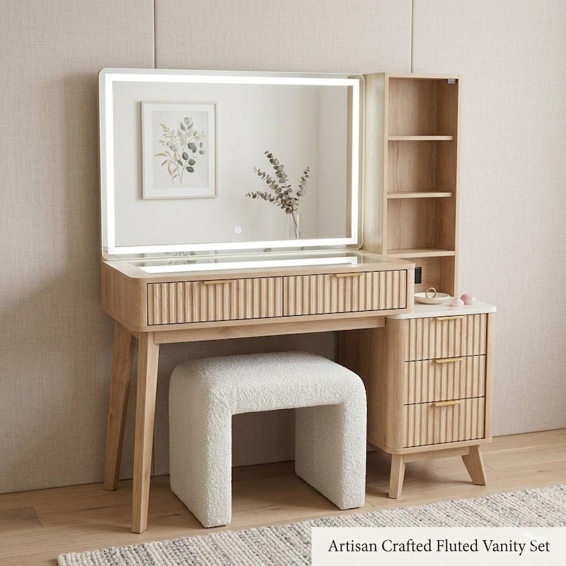 May include: A light wood vanity set featuring a rectangular mirror with integrated LED lighting, a fluted drawer front, and a matching side cabinet with three drawers. The set includes a white textured upholstered stool with a curved base.