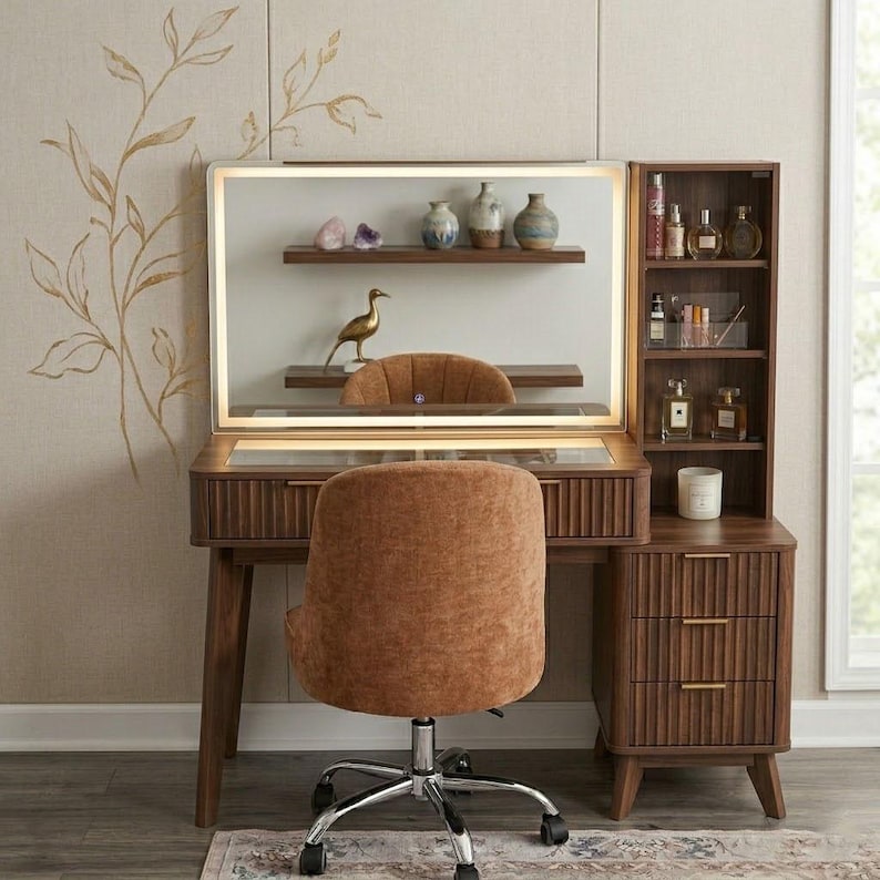 May include: A dark wood vanity desk with a rectangular LED-lit mirror, a glass-top surface, and a side storage unit featuring three drawers and open shelves. A textured brown upholstered swivel chair with a chrome base sits in front of the desk.