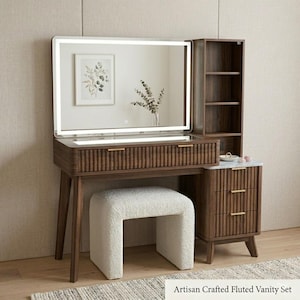 May include: A dark wood vanity set featuring a rectangular mirror with integrated LED lighting, a single drawer with fluted detailing and gold handles, a side cabinet with three drawers, open shelving, and a white textured upholstered stool.