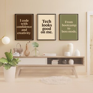 May include: Three framed motivational posters with text in brown and white on a beige background. The posters read "I code with confidence and creativity", "Tech looks good on me", and "From bootcamp to boss mode."