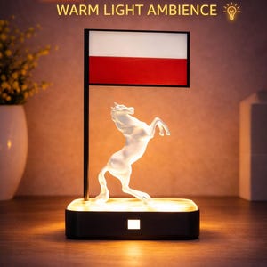Könnte beinhalten: LED-Pferdedekoration mit warmer Lichtstimmung. Eine klare, sich aufbäumende Pferdfigur wird von einem warmen Licht beleuchtet. Der Sockel ist schwarz und rechteckig. Über dem Pferd befindet sich ein schwarzer Pfosten mit einem weißen und roten Rechteck.