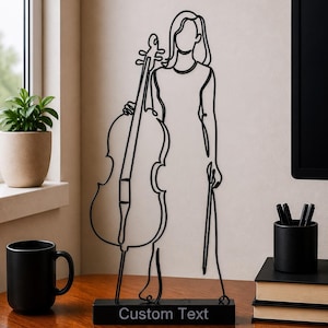 Könnte beinhalten: Schwarze Metallskulptur einer Person, die ein Cello hält. Die Skulptur ist ein durchgehendes Liniendesign, mit Cello und Figur in minimalistischem Stil. Die Basis trägt den weißen Text "Custom Text".