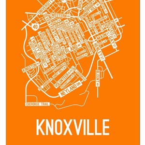 May include: A white and orange map of Knoxville, Tennessee, with the city name printed in large white letters at the bottom. The map features major streets and roads, including Neyland Drive, University Avenue, and Broadway. The map is set against a bright orange background.