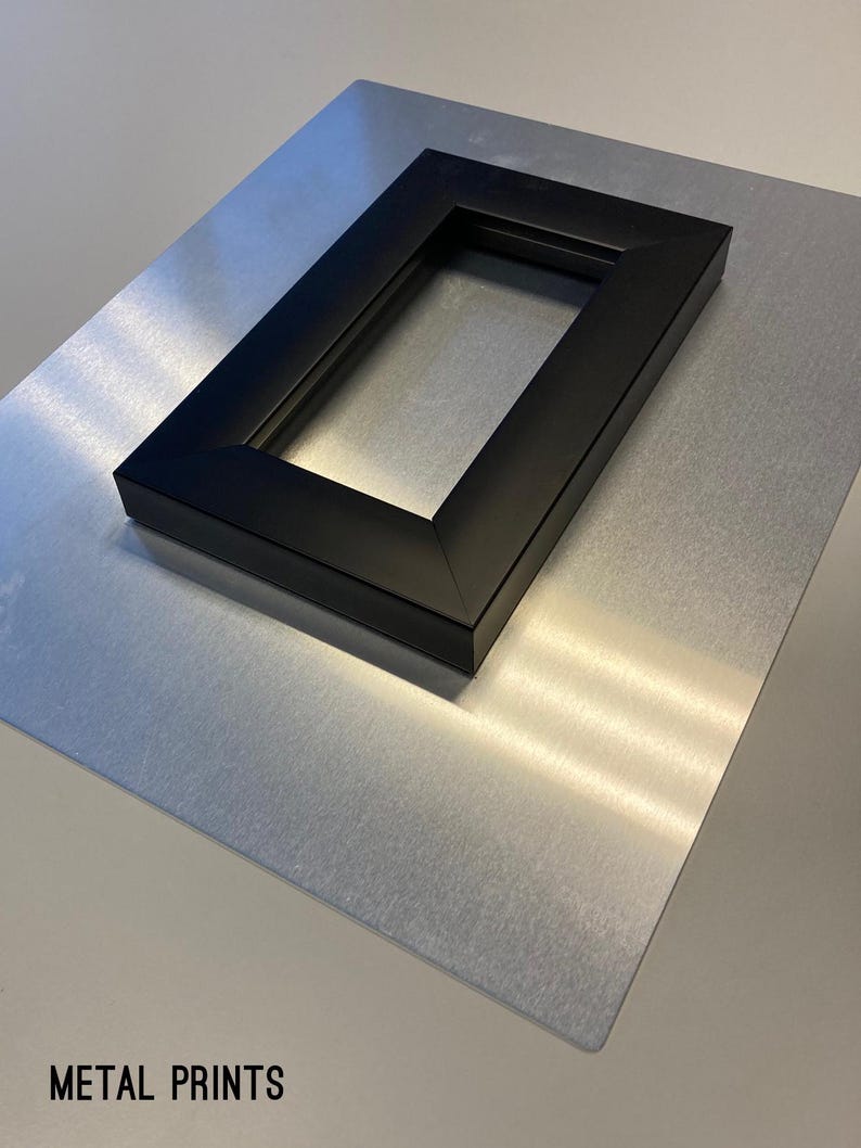May include: A metal print with a black frame. The print is on a silver background. The text "METAL PRINTS" is printed on the bottom of the image.