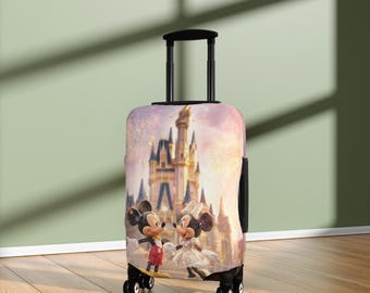 May include: A wheeled suitcase with a vibrant image of Mickey and Minnie Mouse in front of a castle. The suitcase has a black handle and wheels. The background features fireworks and a pink sky.