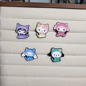 May include: Five enamel pins featuring different cartoon characters wearing various animal costumes. The characters are all wearing different colored outfits, including purple, pink, yellow, blue, and green.