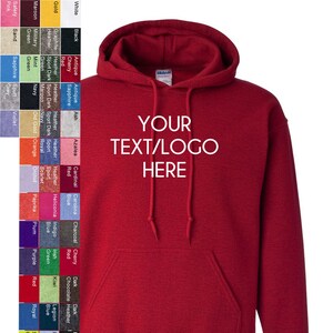 May include: A red hooded sweatshirt with a large pocket on the front. The text "YOUR TEXT/LOGO HERE" is printed on the front of the sweatshirt.