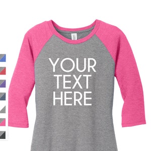 May include: A heather grey and pink baseball tee with the text "YOUR TEXT HERE" in white.