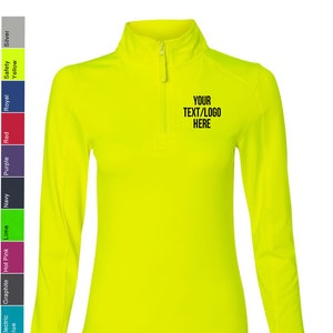 May include: A bright yellow long-sleeved shirt with a mock neck and a zipper. The shirt has a black embroidered design that says "YOUR TEXT/LOGO HERE".