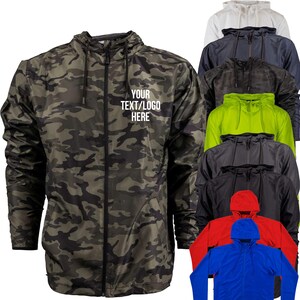 May include: A camouflage print jacket with a hood and a full-length zipper. The text "YOUR TEXT/LOGO HERE" is printed on the front. Additional jackets in white, navy, camo, neon green, gray, black, red, and blue are also shown.