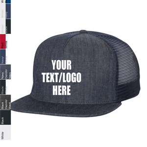 May include: A dark blue denim trucker hat with a black mesh back. The hat has white text that says "YOUR TEXT/LOGO HERE".